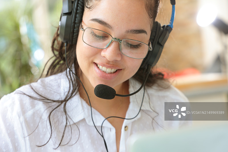 戴着耳机的女人看着屏幕图片素材