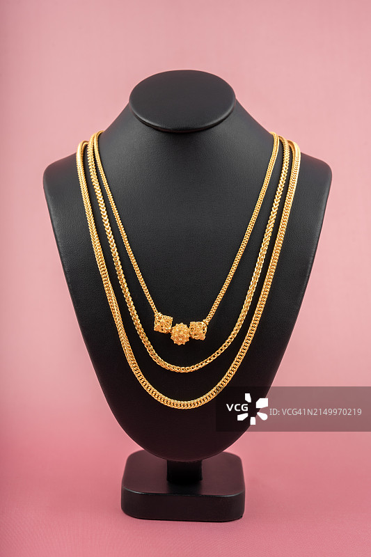 粉色面料上展示的黄金项链图片素材