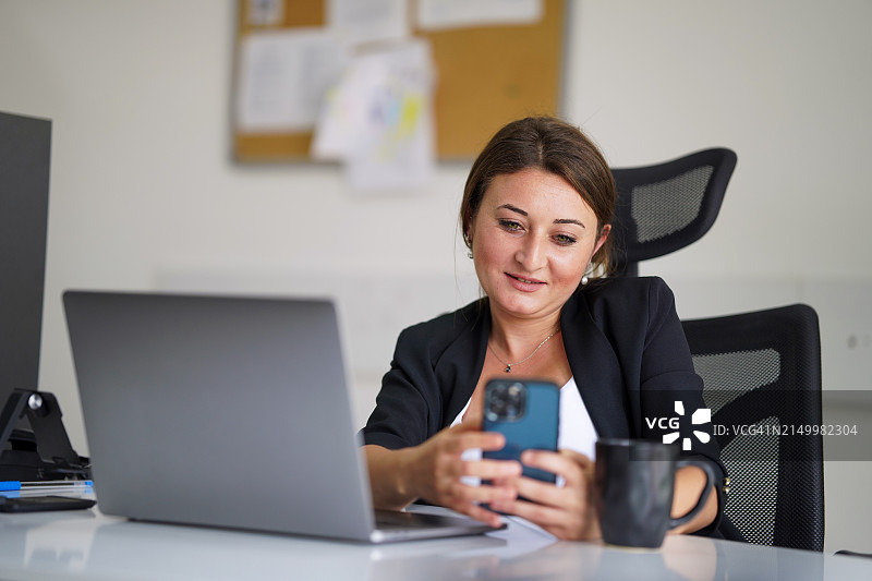 女商人工作中用手机进行视频聊天图片素材