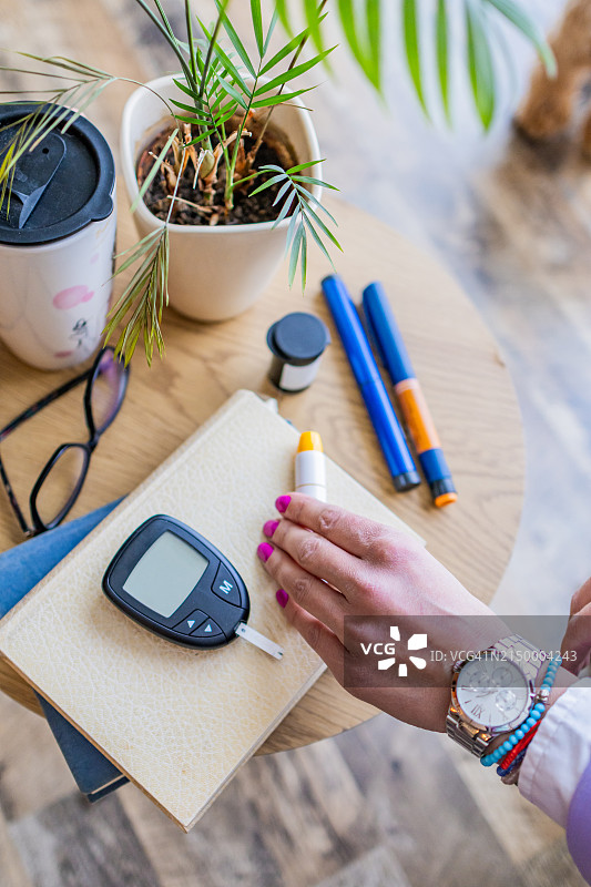 特写：女性在家准备注射胰岛素，检测血糖图片素材