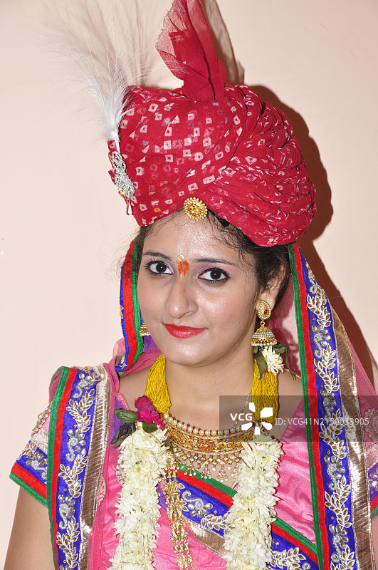 身穿传统服饰靠墙站立的年轻女子肖像图片素材