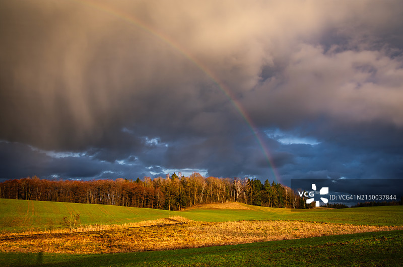 彩虹天空下的田野风光图片素材