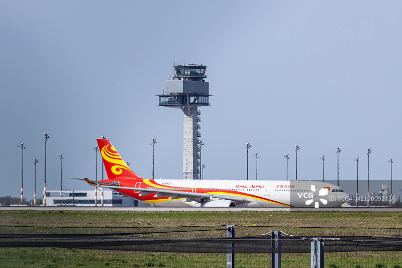 海南航空公司的空客A330在柏林勃兰登堡国际机场的飞行控制塔前准备起飞前往中国北京图片素材