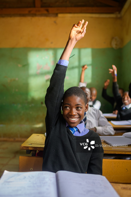 在学校举手的非洲男学生肖像图片素材