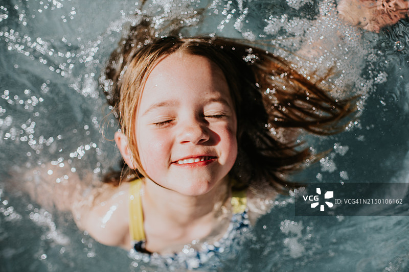 一位在游泳池里自信快乐的孩子图片素材