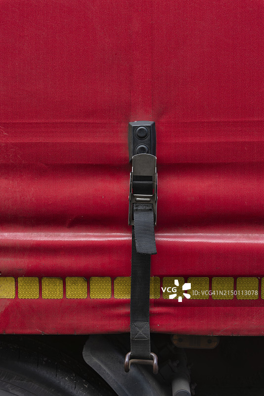 用黑色拉紧带固定的卡车红色防水布图片素材