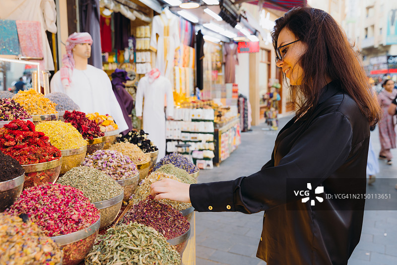 女人在迪拜香料和染料市场购物图片素材
