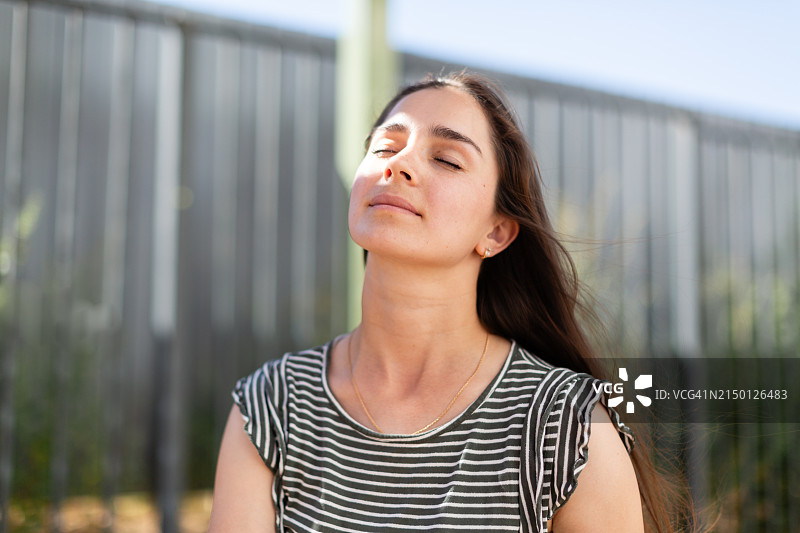 在户外享受阳光的年轻女人图片素材