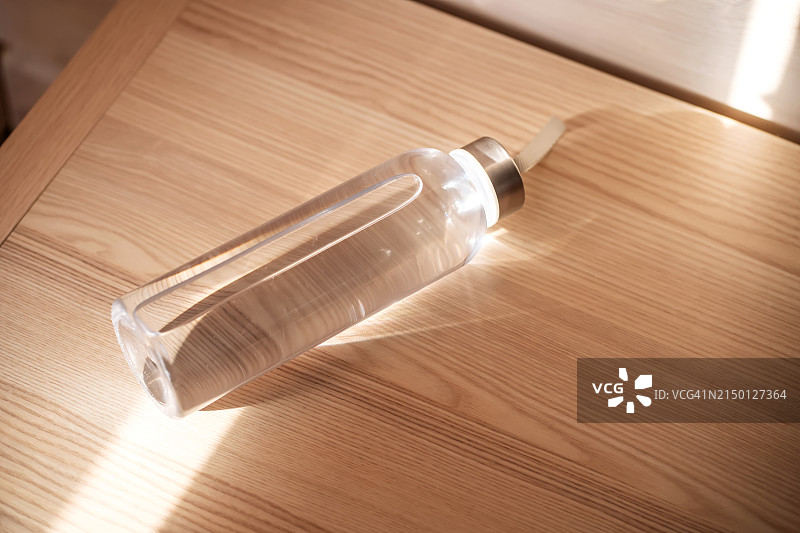 清晨阳光下床头柜上的一瓶过滤水图片素材