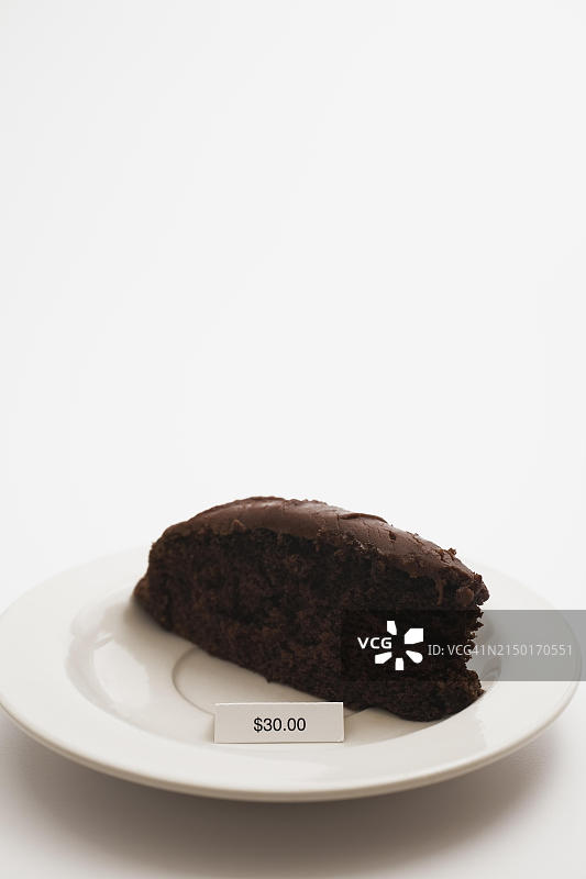 白色背景上的巧克力蛋糕切片特写，价格标签30美元，加拿大魁北克图片素材