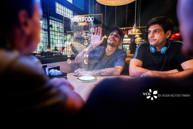 年轻男人在餐厅使用增强现实设备点餐图片素材