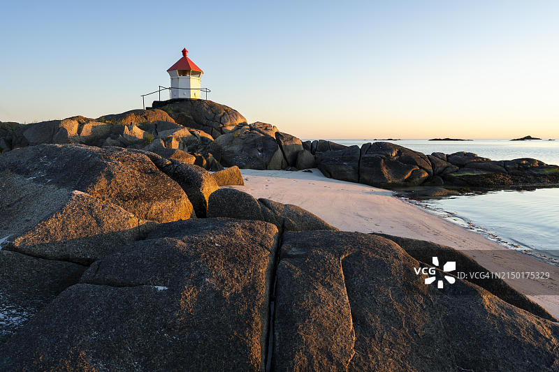 罗弗敦群岛海景：埃格姆沙滩上的小灯塔，午夜阳光下的海 Rocks图片素材