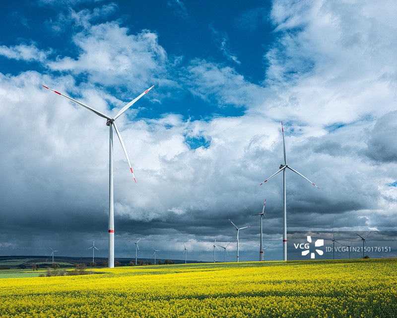 德国图林根油菜田中的风力涡轮机图片素材