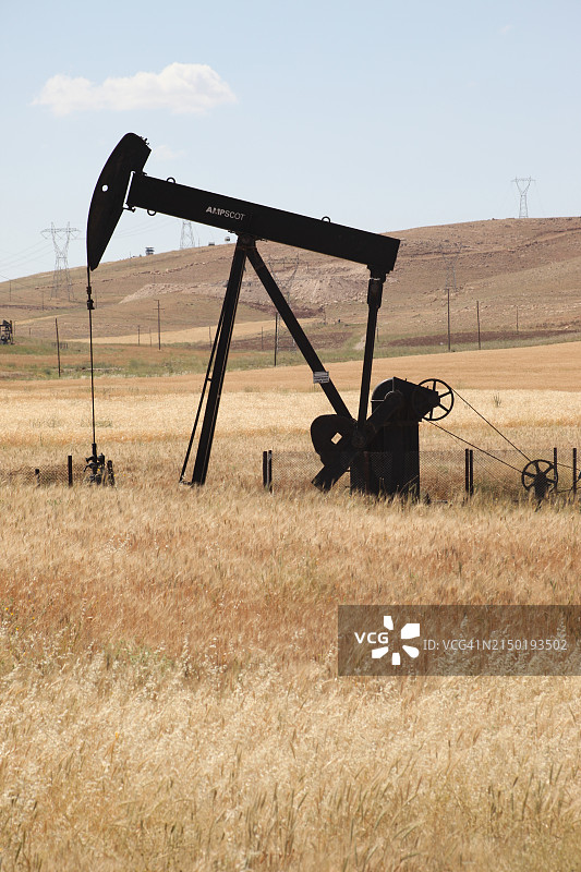 油井旁的老式抽油泵图片素材