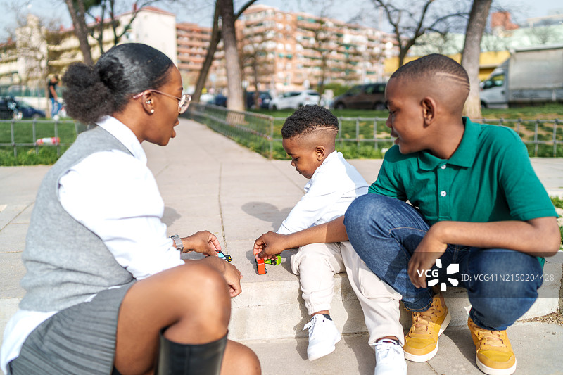 母子在公园的楼梯上玩玩具，享受美好时光图片素材