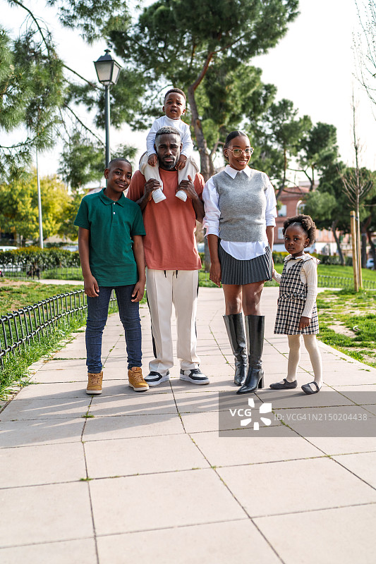 充满活力的城市公园里，快乐的非洲家庭在小路上散步图片素材