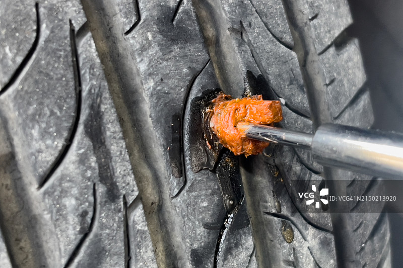 轮胎上扎着钉子，轮胎已磨损并有孔洞图片素材