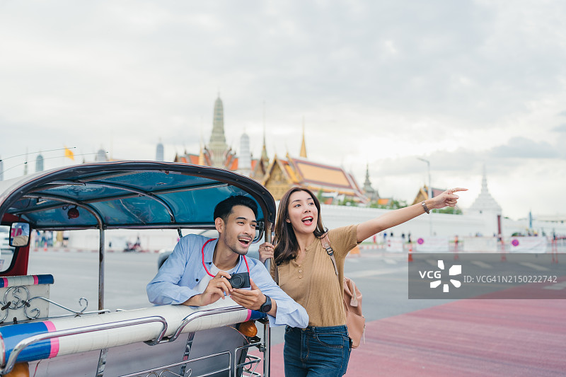 在泰国曼谷玉佛寺乘坐嘟嘟车的亚洲夫妇图片素材