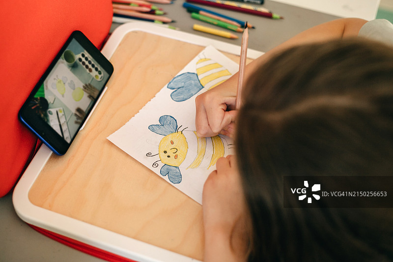 俯视：女孩用铅笔画蜜蜂情侣图片素材