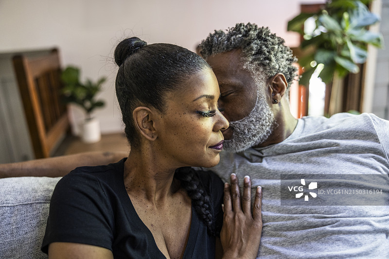 老年夫妇在家中沙发上拥抱图片素材