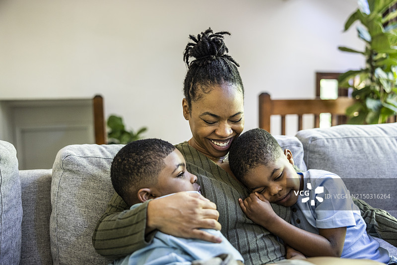 母子在家里的沙发上拥抱欢笑图片素材