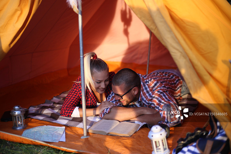 快乐的年轻夫妇和他们的狗一起露营图片素材