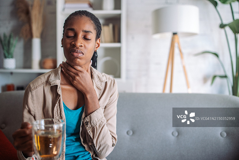 女人喝茶时感到喉咙痛图片素材