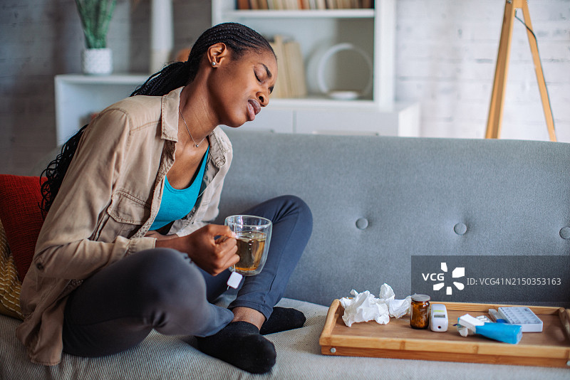 女人坐在桌旁，桌上有茶和纸巾图片素材