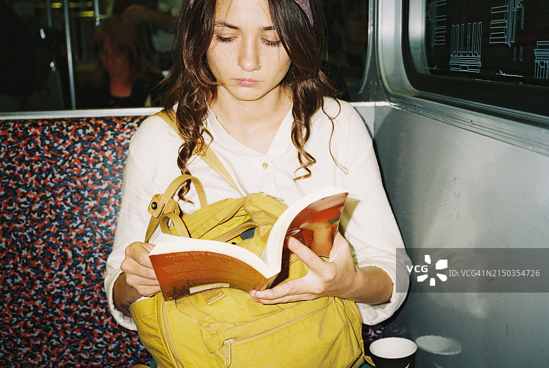 女人在地铁上阅读书籍图片素材