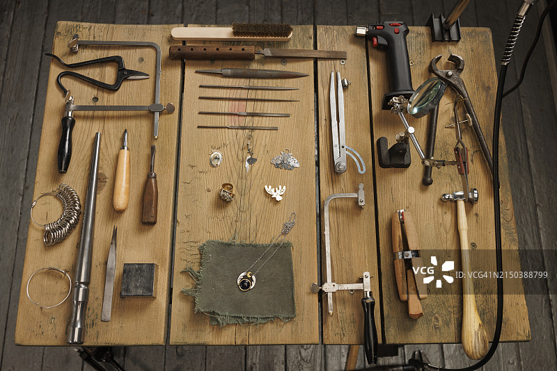 珠宝工匠工作室，乡村木桌上的复古和现代珠宝工具图片素材