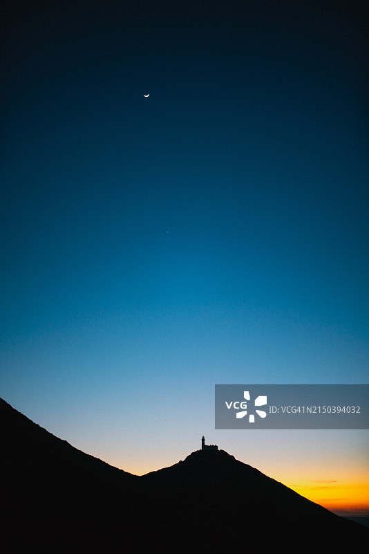 日落时山顶上的灯塔图片素材