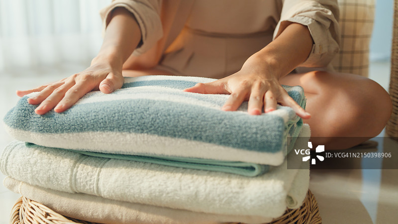 美丽的年轻亚洲女人在家洗衣服的特写。家中的日常生活活动图片素材