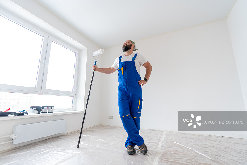 正在查看空荡荡白色房间的油漆工，准备粉刷图片素材