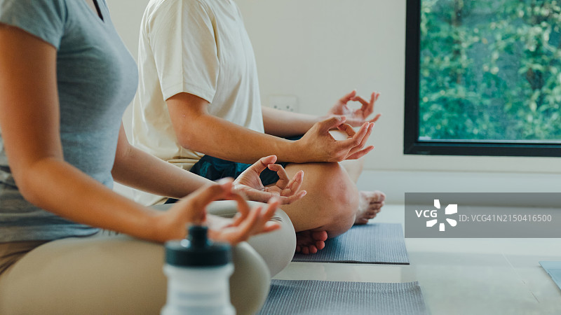 年轻的亚洲夫妇在宁静的家中冥想特写，享受居家健身图片素材