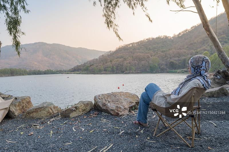 女人在傍晚的湖边放松图片素材