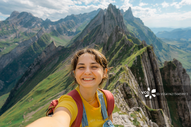 在瑞士阿尔卑斯山脊徒步的快乐女子自拍像图片素材