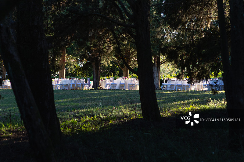 日落时分森林中的一组白色餐桌和椅子图片素材