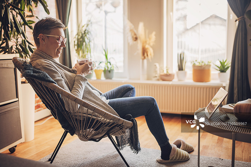 在舒适的地方使用平板电脑的快乐的人图片素材