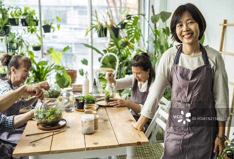 植物玻璃容器工作坊的年轻亚洲女导师肖像图片素材