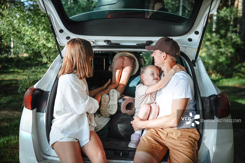 家庭探险：父母和女儿在森林后备箱中寻找快乐图片素材