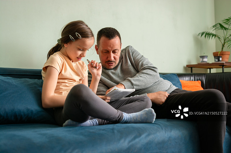 女孩和父亲一起玩数独图片素材