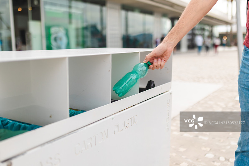 人手丢弃塑料瓶特写图片素材