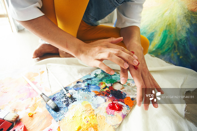 涂有鲜艳颜料的艺术家手部特写图片素材
