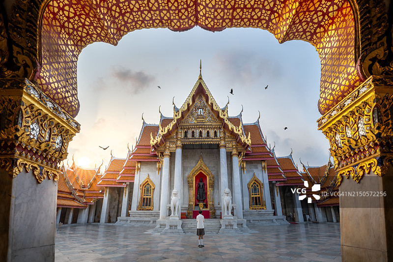 在泰国，日出时男子在寺庙祈祷图片素材