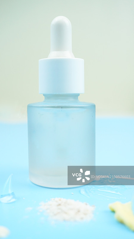 蓝色背景上的滴管玻璃瓶面部精华特写图片素材