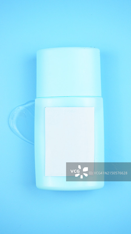 蓝色背景上的透明乳液凝胶美容护肤精华液瓶图片素材
