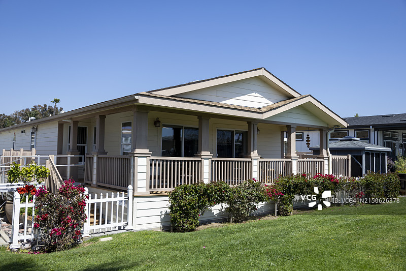 移动房屋公园中带门廊和花园的预制房屋背面图片素材