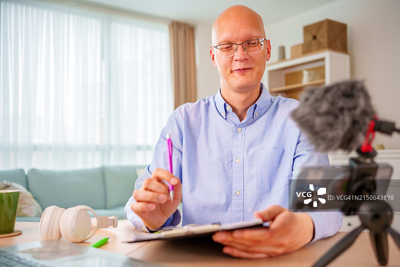 快乐的年轻秃头男子与医生进行视频通话图片素材