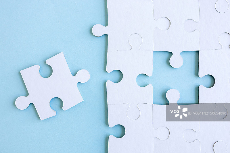 蓝色背景上的拼图碎片，俯视特写图片素材