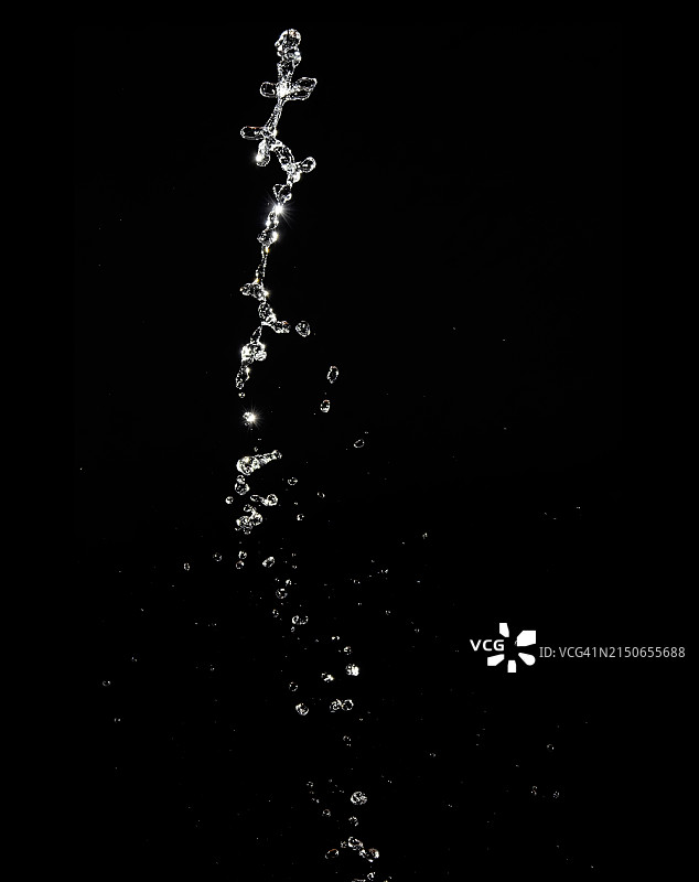 黑色背景上向上运动的天然水飞溅和滴落图片素材